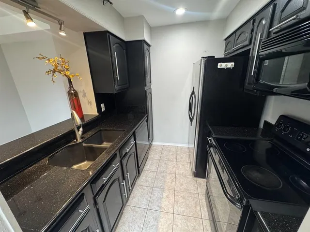 a kitchen with a refrigerator and a stove top oven