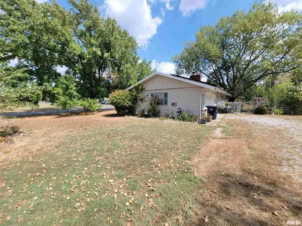 a front view of house with yard and trees in the background