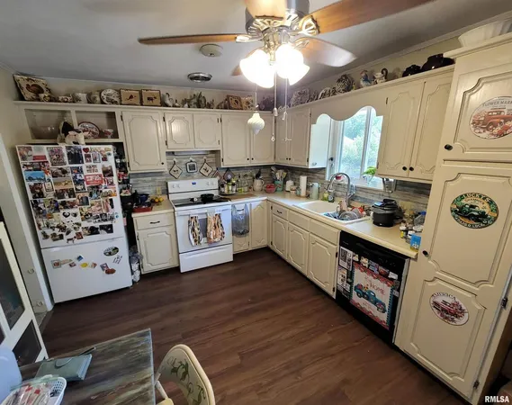 a kitchen with stainless steel appliances a stove a sink and white cabinets with wooden floor