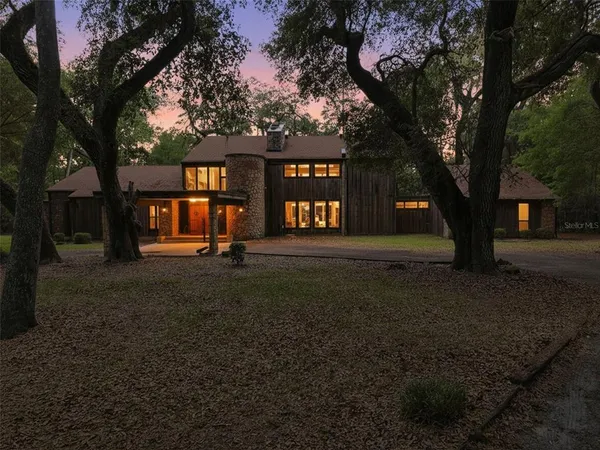a front view of a house with a tree
