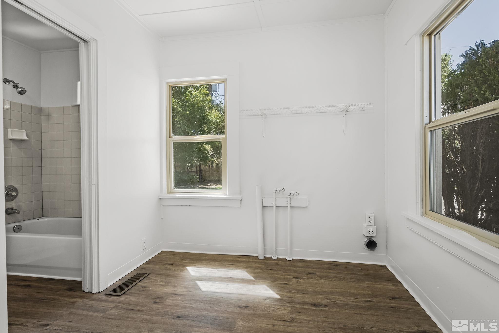 971 Lester Avenue Reno, NV 89502 - Photo 12 of 15 a view of an empty room with a window and wooden floor