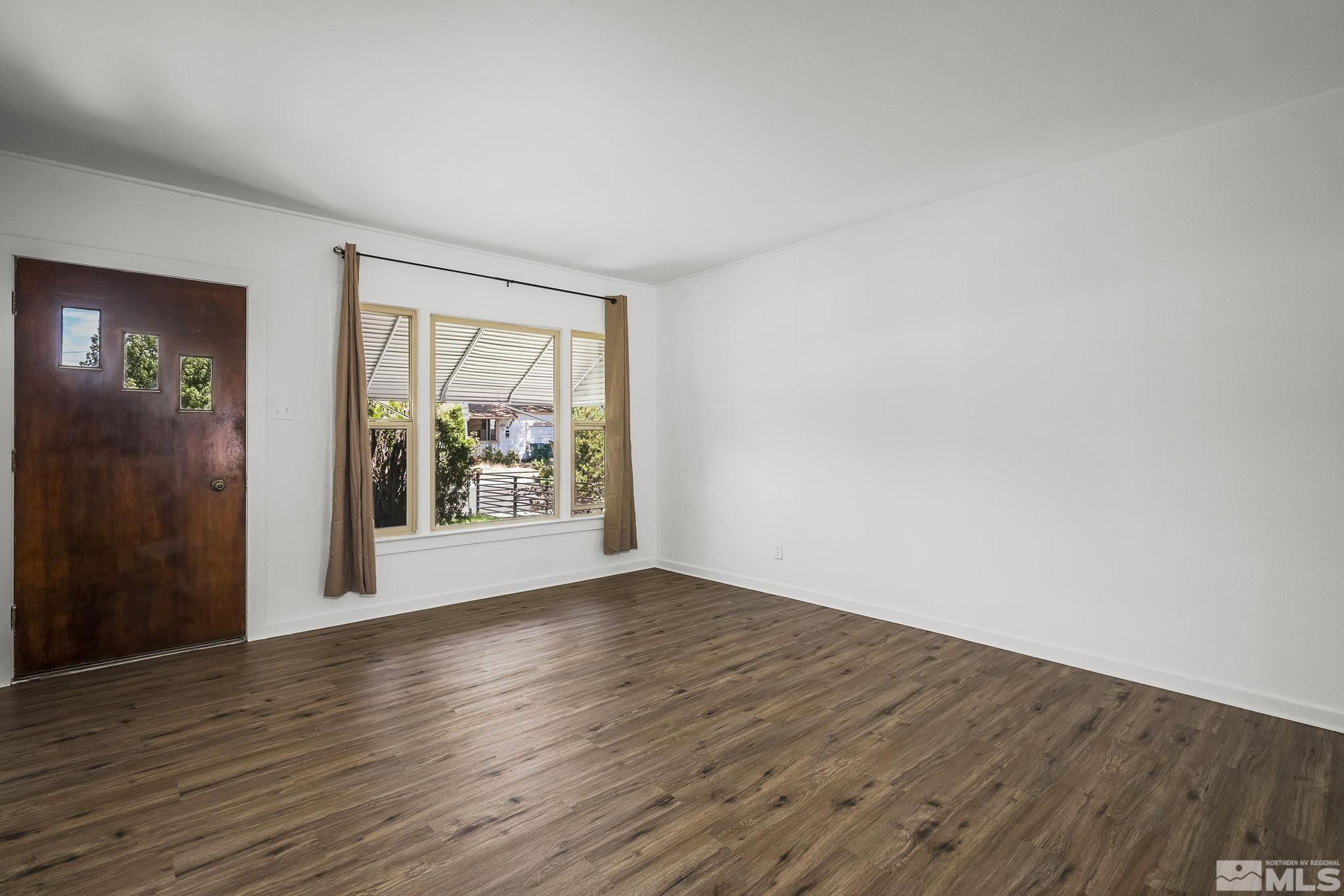 971 Lester Avenue Reno, NV 89502 - Photo 4 of 15 a view of an empty room with wooden floor and a window