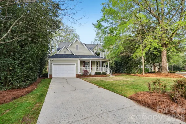a front view of a house with a yard and trees