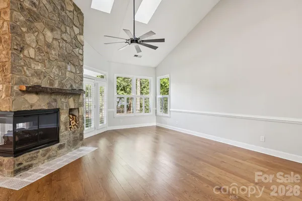a view of an empty room with a fireplace and a window