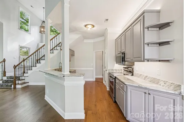 a kitchen with stainless steel appliances kitchen island granite countertop a stove a sink and a refrigerator