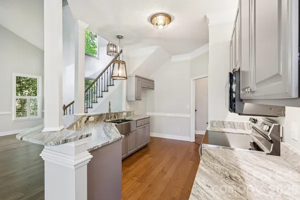 a kitchen with granite countertop a sink stove and cabinets