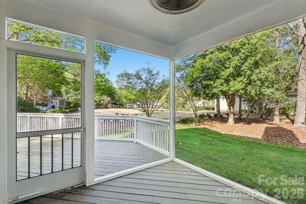a view of a deck with a big yard potted plants and large tree