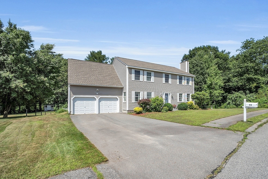 34 Pingry Way Ayer, MA 01432 - Photo 2 of 29 a front view of a house with a yard and garage