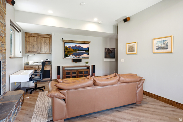 3148 Lower Saddleback Road Park City, UT 84098 - Photo 48 of 67 Living area featuring wood-finish flooring, a stone accent wall, recessed lighting, and a built-in workstation with wood cabinetry