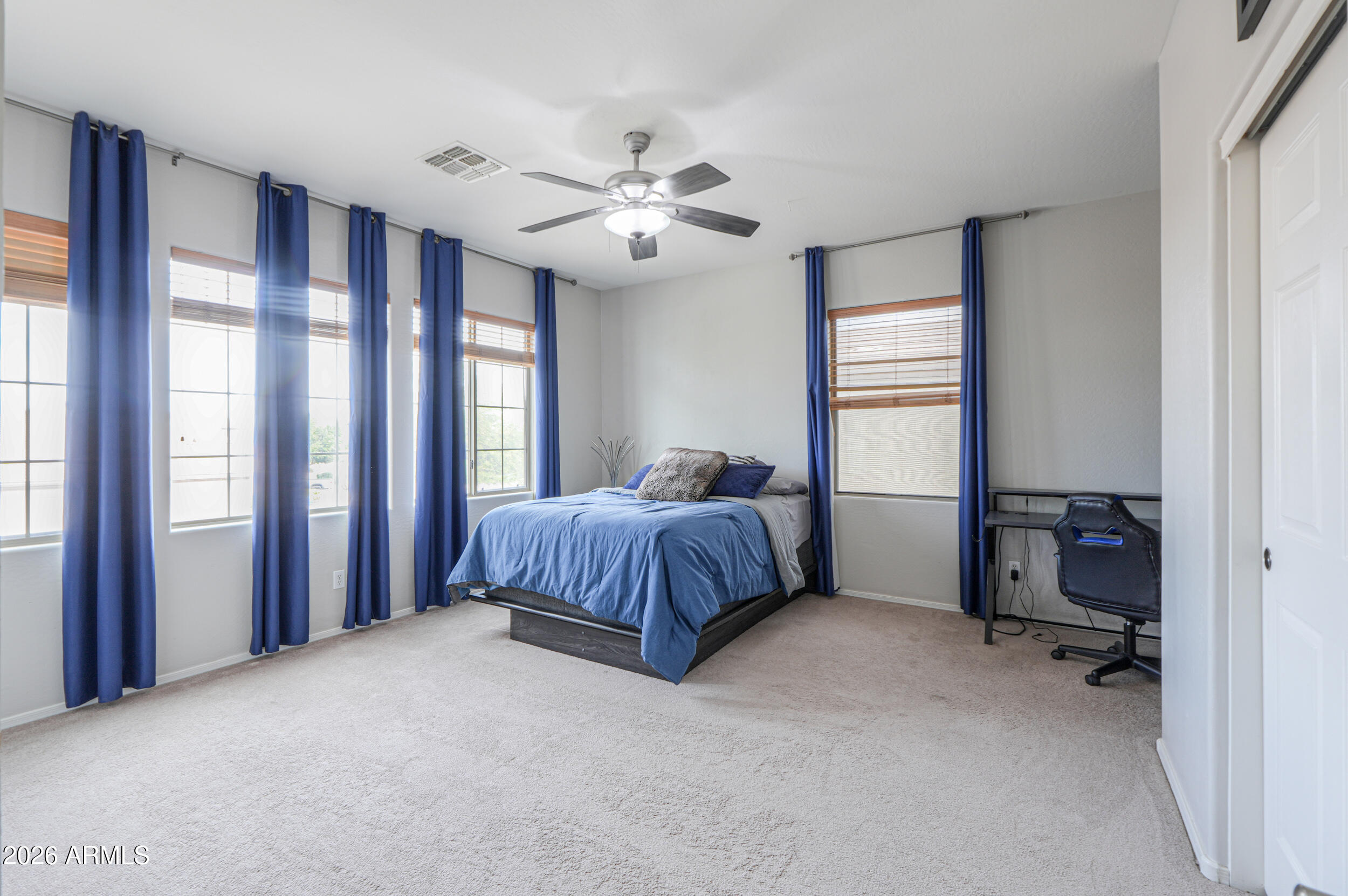 45247 West Jack Rabbit Trail Maricopa, AZ 85139 - Photo 47 of 75 a spacious bedroom with a large bed and a chandelier