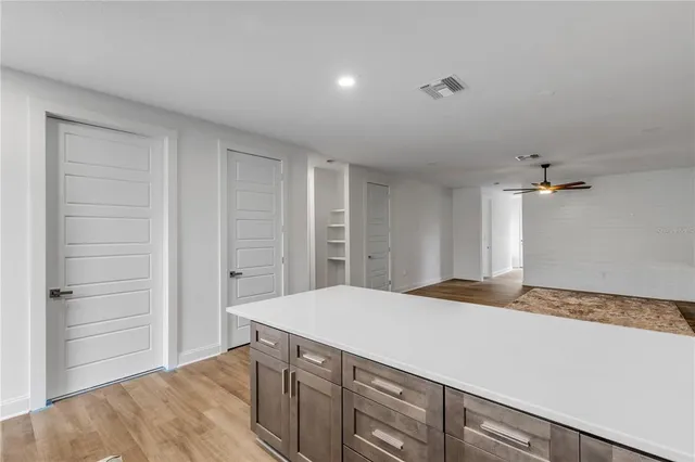 a kitchen with a wooden floor and cabinets