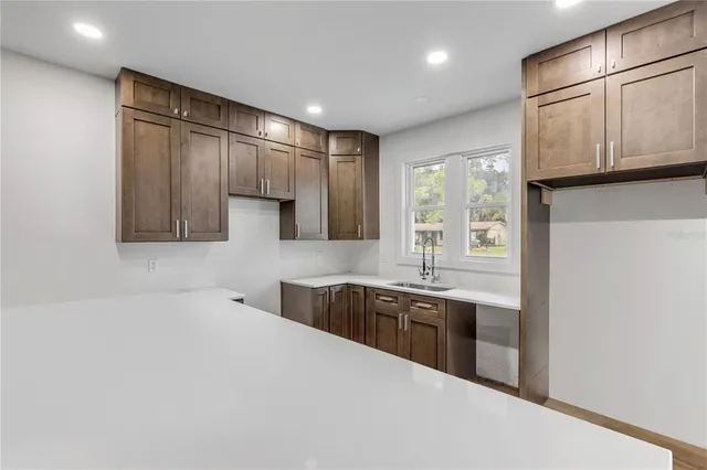 a kitchen with stainless steel appliances granite countertop a sink and cabinets with wooden floor