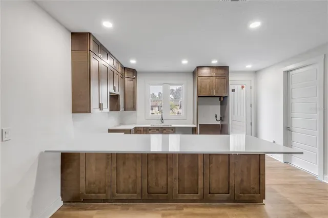a large kitchen with stainless steel appliances granite countertop a large counter top and a wooden floors