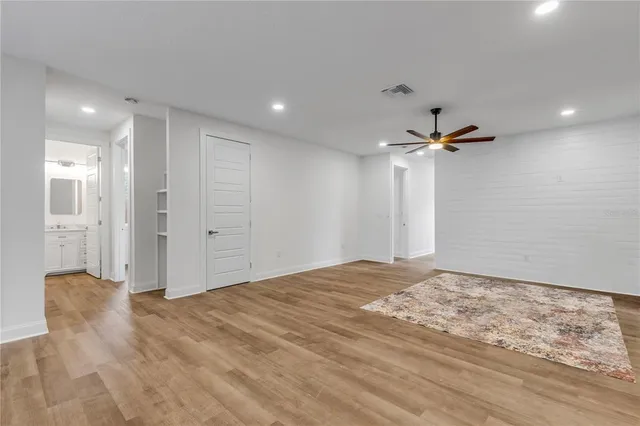 a view of a livingroom with a ceiling fan & entryway