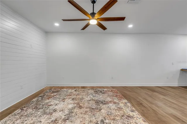 an empty room with a window and a ceiling fan