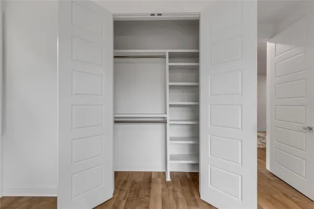 a view of walk in closet with empty racks