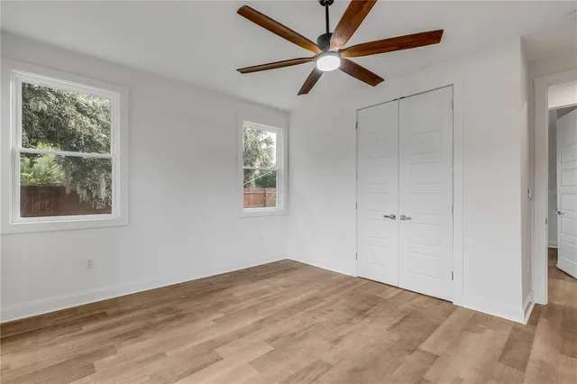 a view of a big room with wooden floor and windows
