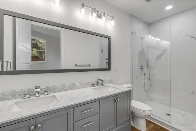 a bathroom with a granite countertop sink toilet and shower