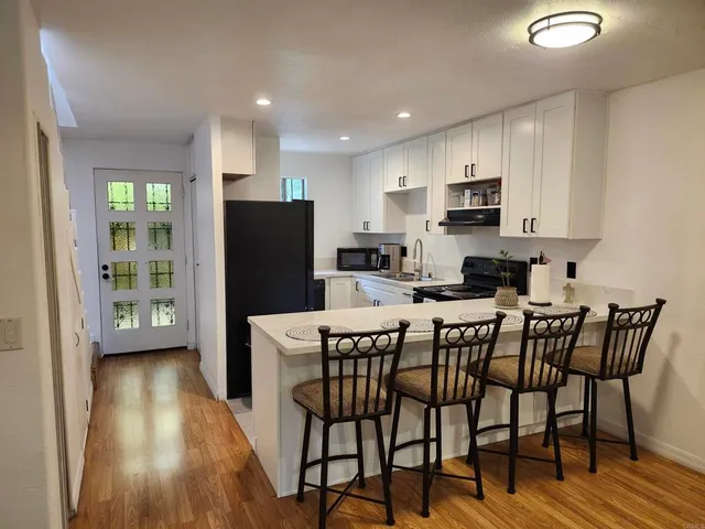 a kitchen with a table chairs refrigerator and microwave