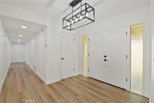 a view of a hallway with wooden floor and closet area