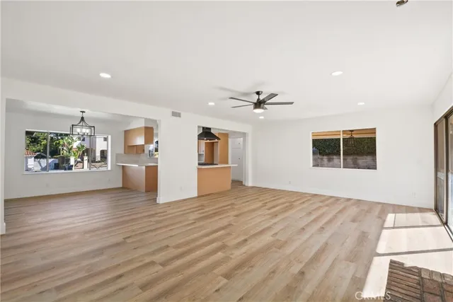 a view of an empty room with window and wooden floor