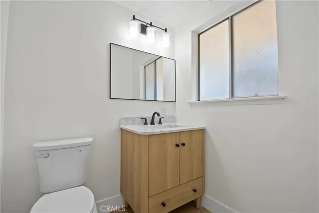 a bathroom with a toilet a sink and mirror