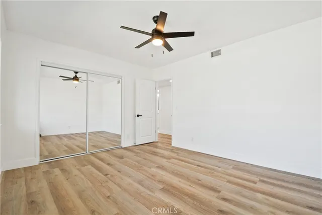 an empty room with ceiling fan and window