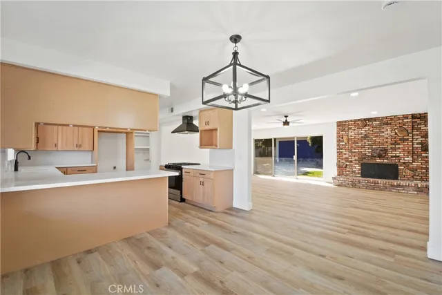 a large kitchen with cabinets wooden floor and a fireplace