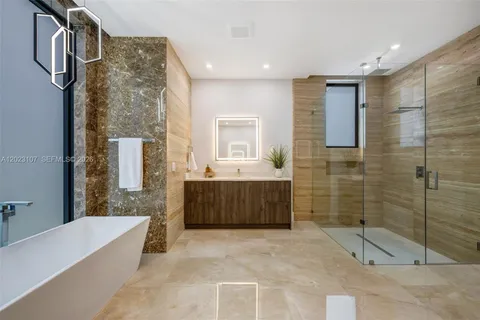 a bathroom with a tub sink shower and mirror