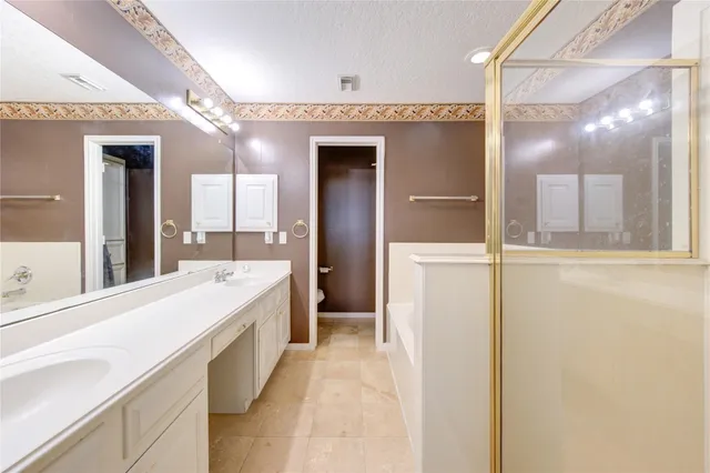 an empty room with windows and chandelier fan