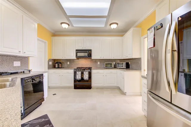 a large white kitchen with a large window