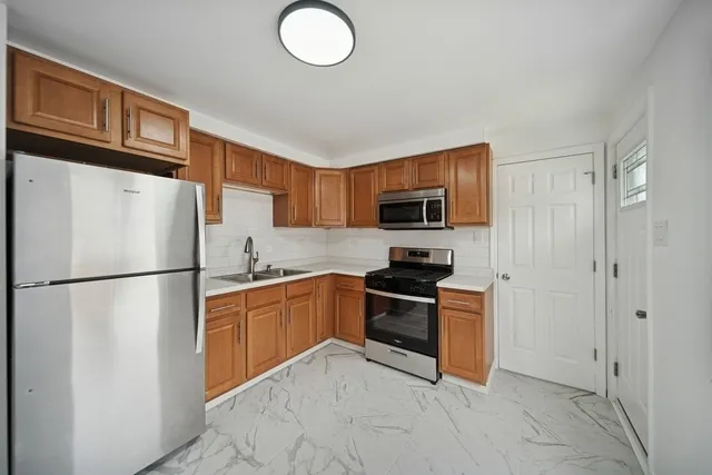 a kitchen with stainless steel appliances granite countertop a refrigerator stove a sink dishwasher and microwave