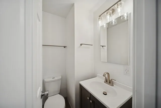 a bathroom with a toilet a sink and mirror