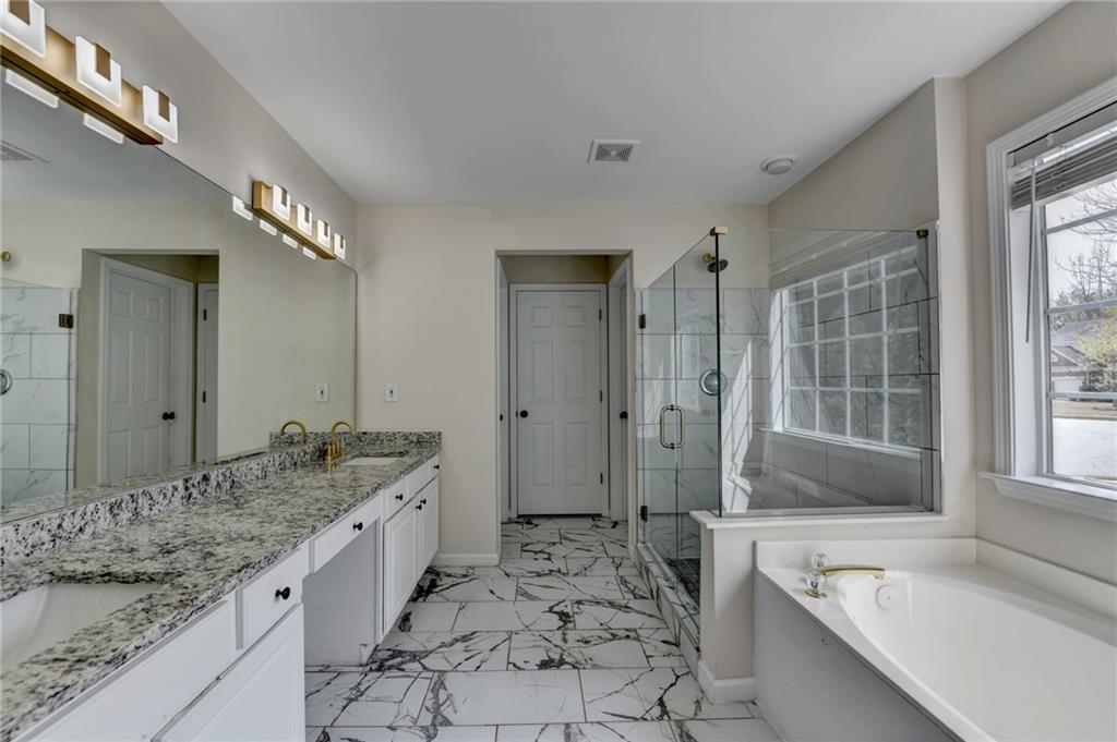 100 Hawnley Trc Northwest Suwanee, GA 30024 - Photo 41 of 58 a spacious bathroom with a granite countertop tub sink and mirror