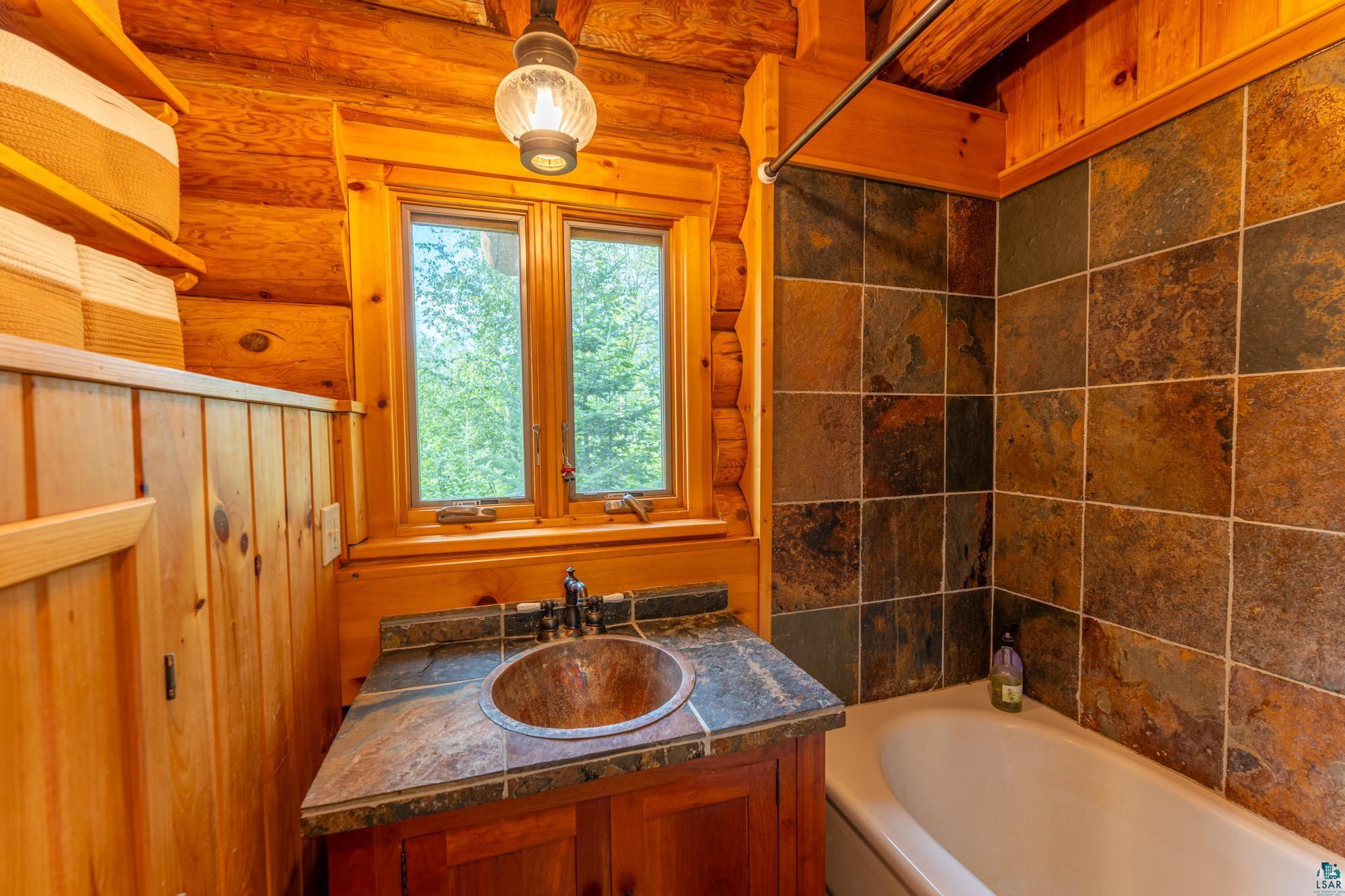 1911 Grouse Ridge Road Ely, MN 55731 - Photo 12 of 42 Bathroom with vanity and rustic walls
