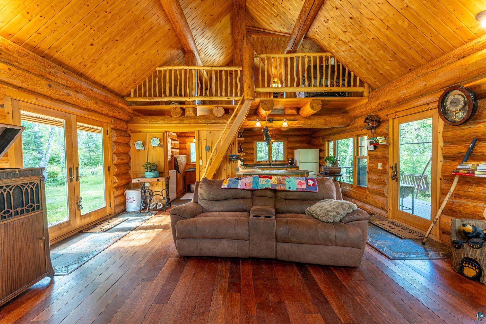 1911 Grouse Ridge Road Ely, MN 55731 - Photo 8 of 42 Living room featuring log walls, hardwood / wood-style flooring, and high vaulted ceiling