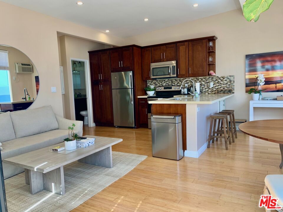 25164 Malibu Road, Unit D Malibu, CA 90265 - Photo 19 of 24 a living room with stainless steel appliances kitchen island granite countertop furniture wooden floor and a view of kitchen