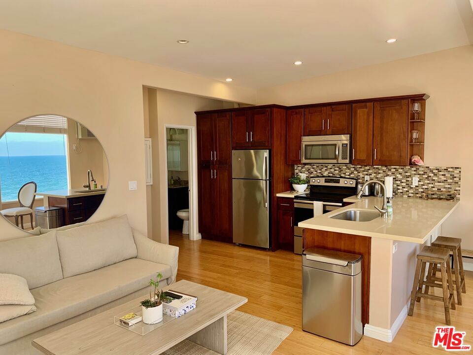 25164 Malibu Road, Unit D Malibu, CA 90265 - Photo 23 of 24 a living room with stainless steel appliances furniture a rug and a kitchen view