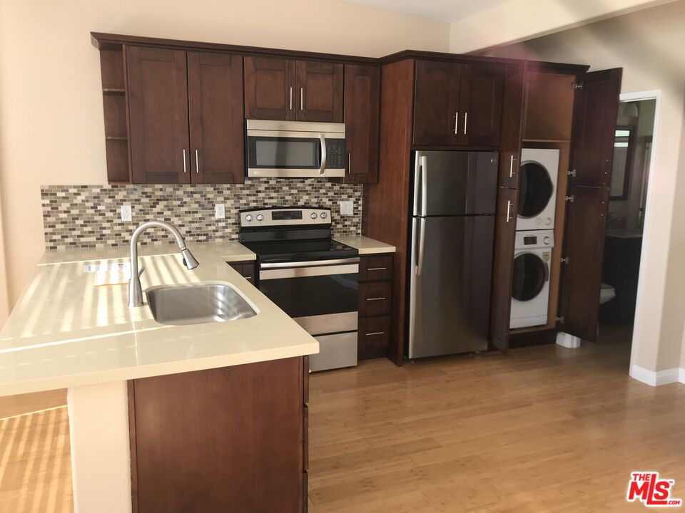 25164 Malibu Road, Unit D Malibu, CA 90265 - Photo 5 of 24 a kitchen with stainless steel appliances granite countertop a refrigerator and a stove top oven