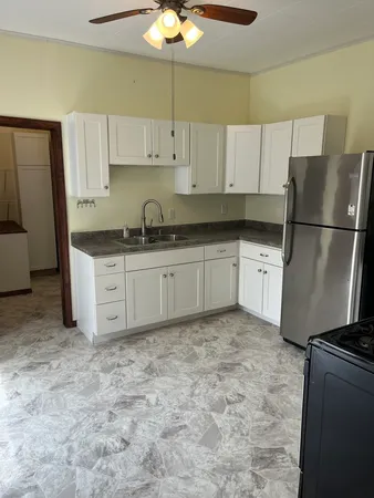 a kitchen with granite countertop a refrigerator a stove a sink a washer and dryer