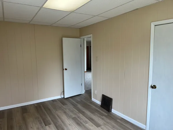 an empty room with wooden floor and windows