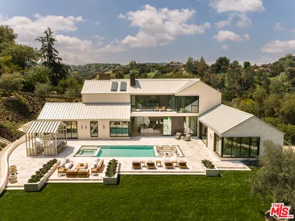 a front view of a house with a garden and trees