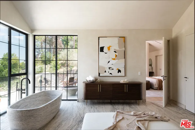 a bedroom with two beds and a large window