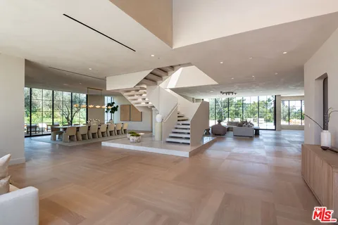 a living room with furniture a couch and a large window