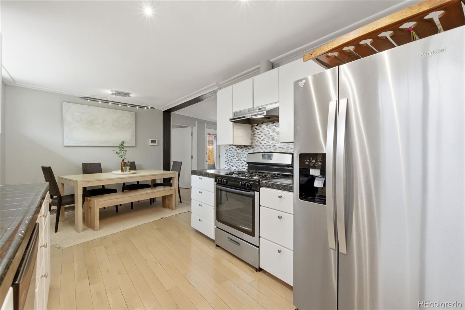 999 South Fillmore Way Denver, CO 80209 - Photo 11 of 37 a kitchen with stainless steel appliances a stove a microwave and a refrigerator