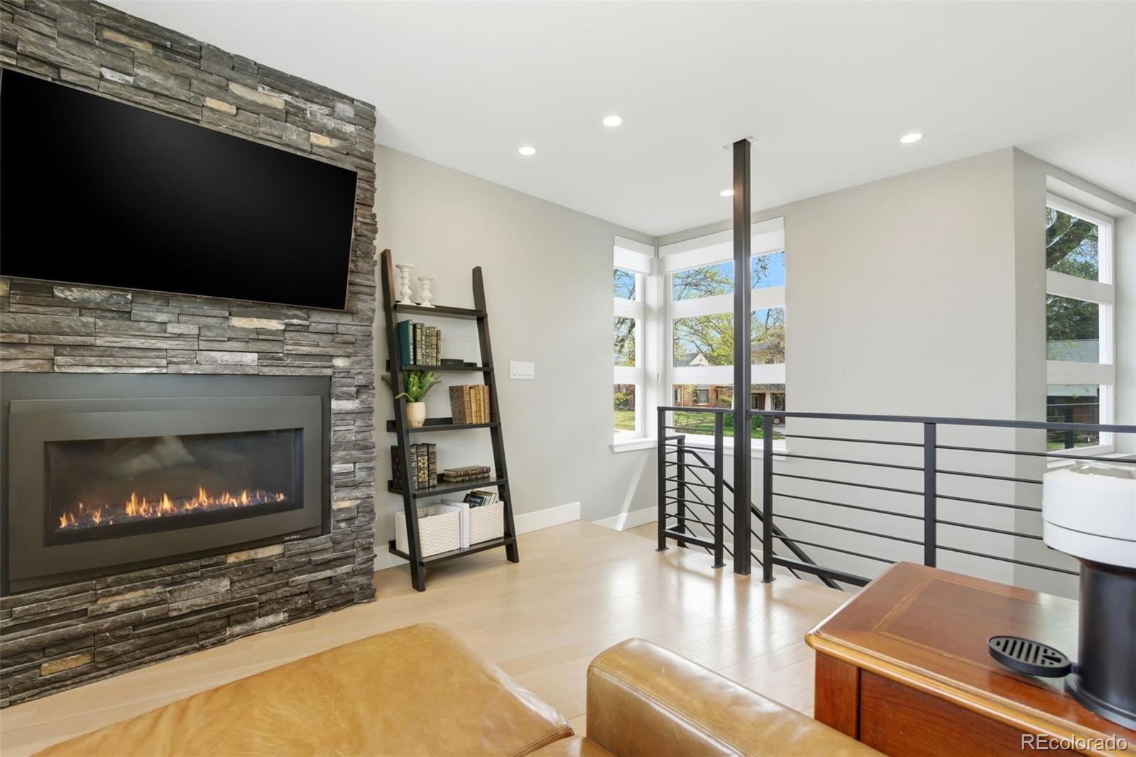 999 South Fillmore Way Denver, CO 80209 - Photo 23 of 37 a living room with furniture a flat screen tv and a fireplace