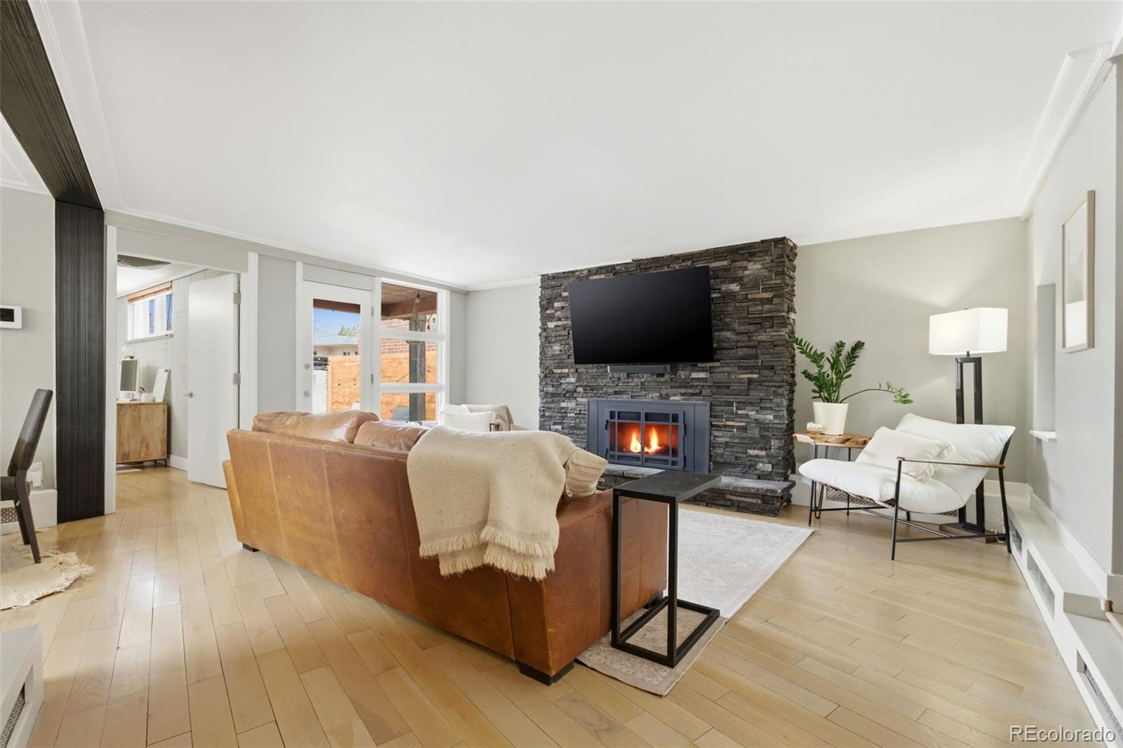 999 South Fillmore Way Denver, CO 80209 - Photo 6 of 37 a living room with furniture a flat screen tv and a fireplace