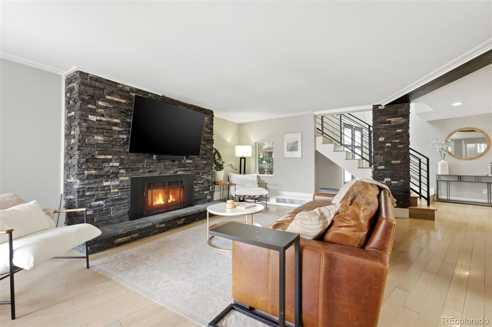 999 South Fillmore Way Denver, CO 80209 - Photo 7 of 37 a living room with furniture a flat screen tv and a fireplace