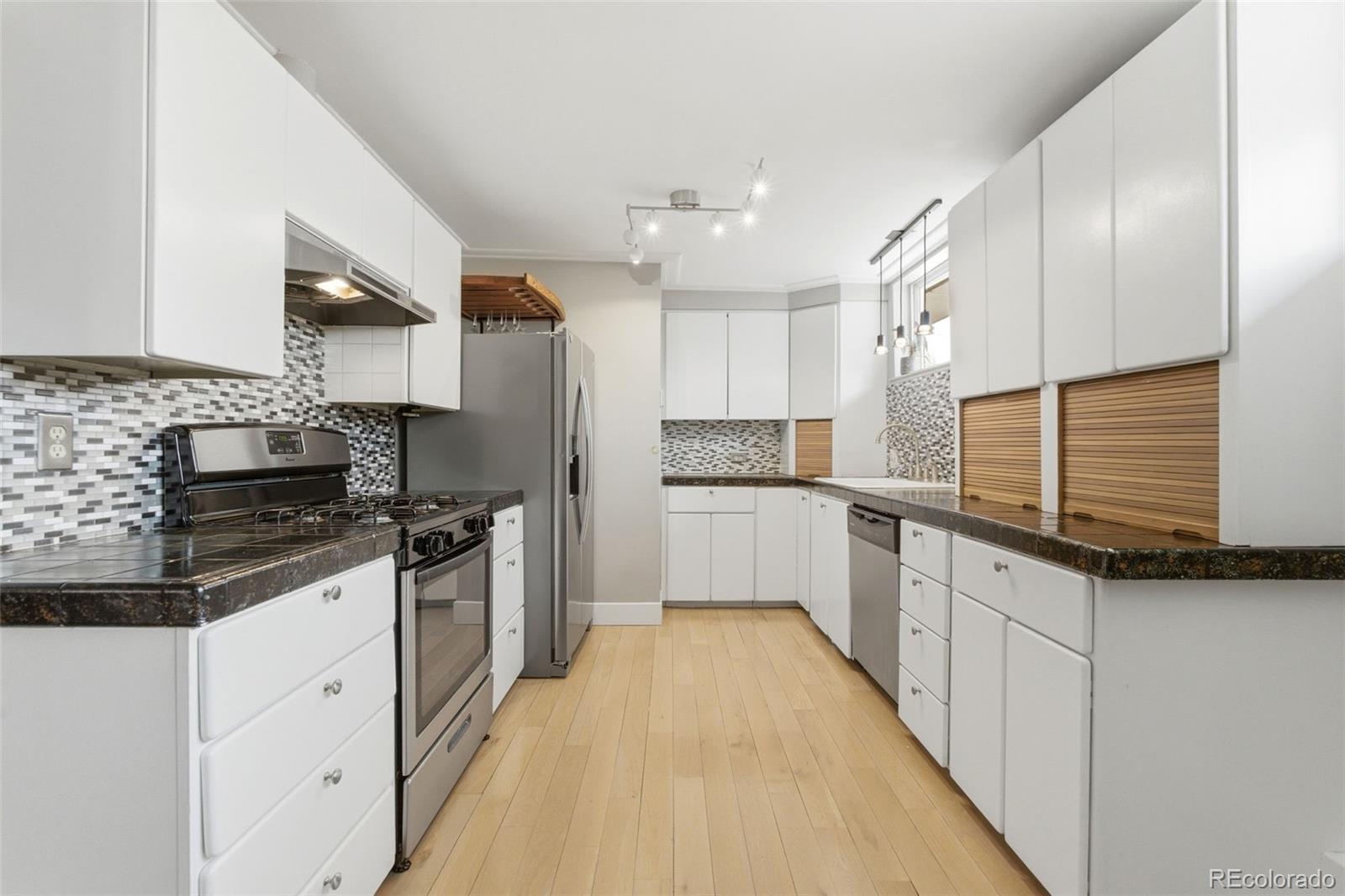 999 South Fillmore Way Denver, CO 80209 - Photo 10 of 37 a kitchen with stainless steel appliances granite countertop a stove a sink and a refrigerator