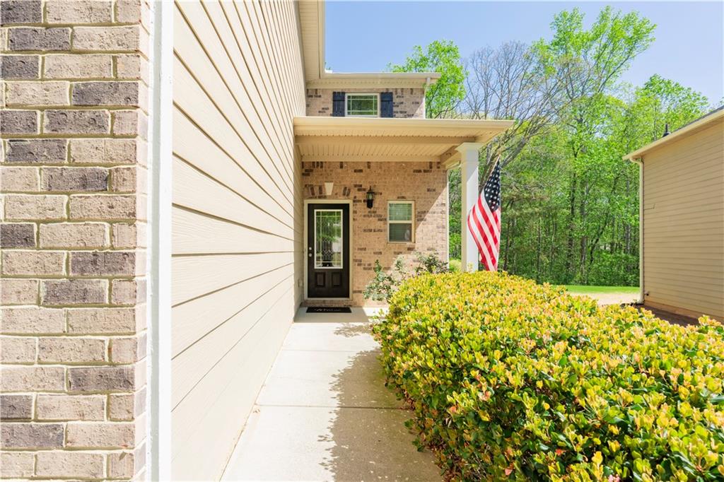 5555 Hedge Brook Drive Cumming, GA 30028 - Photo 3 of 15 a view of a white house with a small yard and potted plants